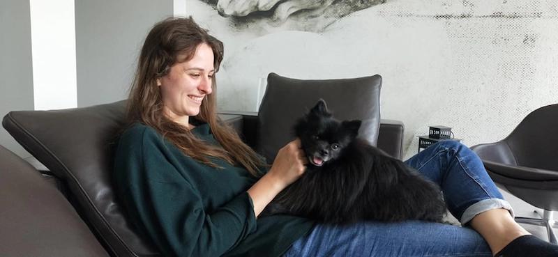 Femme assise avec chien noir sur ses jambes 